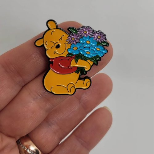 Mavi çiçekler taşıyan winnie the pooh rozet
